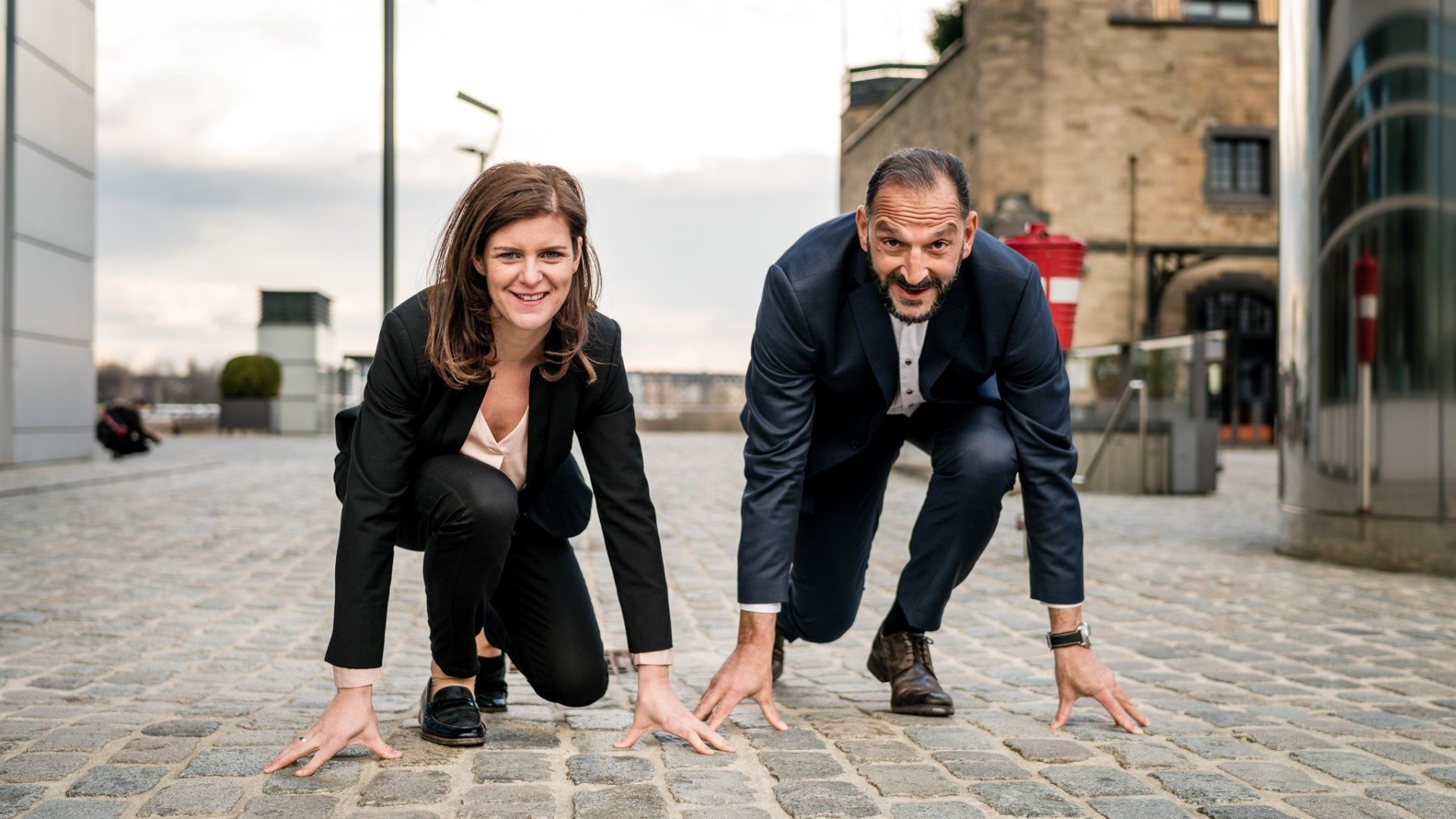 Maja und Tunç Gültekin in Startläufer-Pose auf Kopfsteinpflaster in Köln